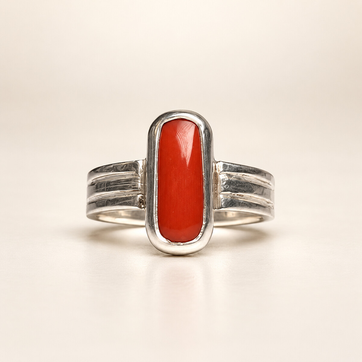 Red Moonga ring set in silver photographed on a warm ivory studio background